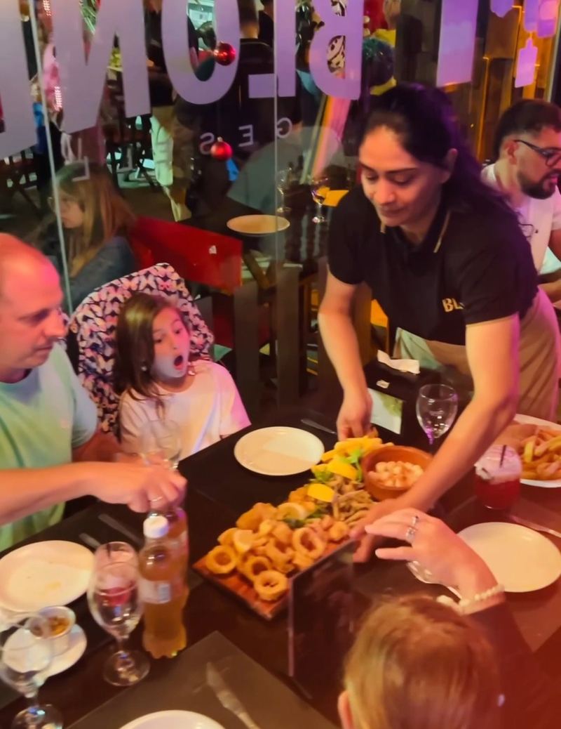 Familia recibiendo una tabla de rabas en su mesa